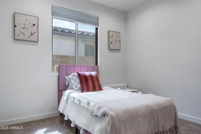 a bedroom with a bed and painting on the wall