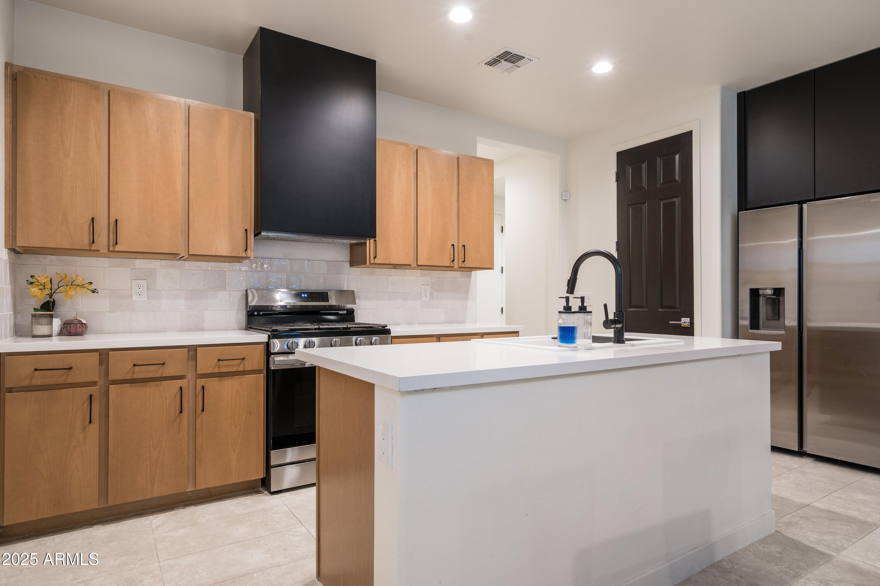 18365 West Ewers Drive Surprise, AZ 85374 - Photo 5 of 18 a kitchen with stainless steel appliances granite countertop a sink stove and refrigerator