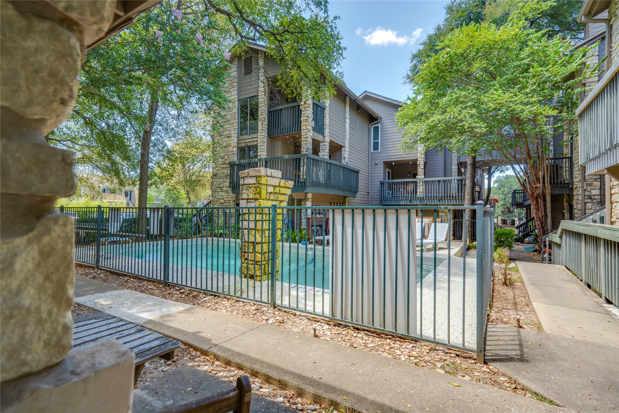 3627 Menchaca Road, Unit 108 Austin, TX 78704 - Photo 24 of 24 A sparkling community swimming pool rests nestled among mature shade trees and multi-level residential structures.
