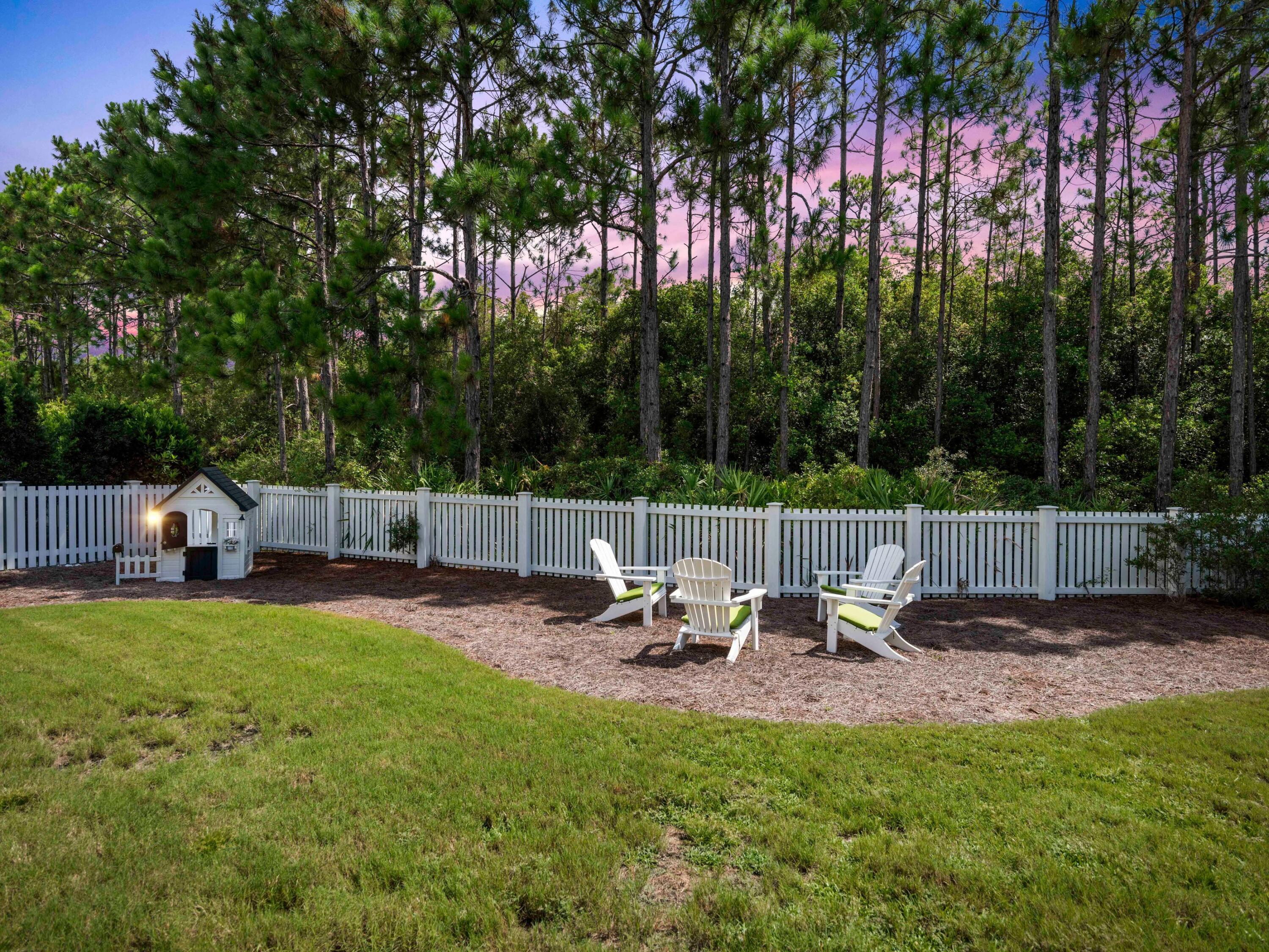 193 Splash Drive Inlet Beach, FL 32461 - Photo 39 of 43 a view of a backyard with table and chairs potted plants and a palm tree
