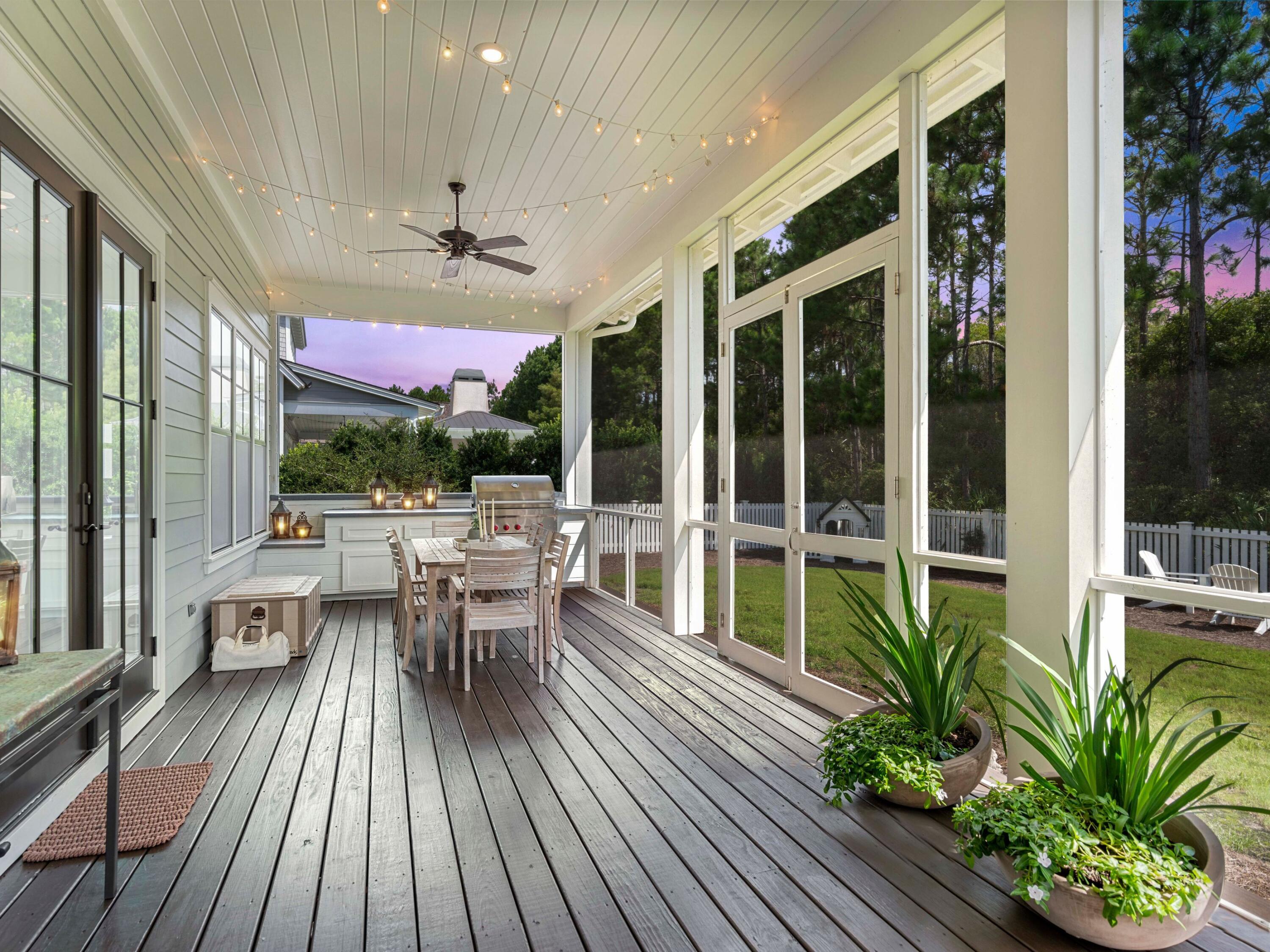 193 Splash Drive Inlet Beach, FL 32461 - Photo 41 of 43 a view of a patio with table and chairs potted plants with wooden floor and floor to ceiling window