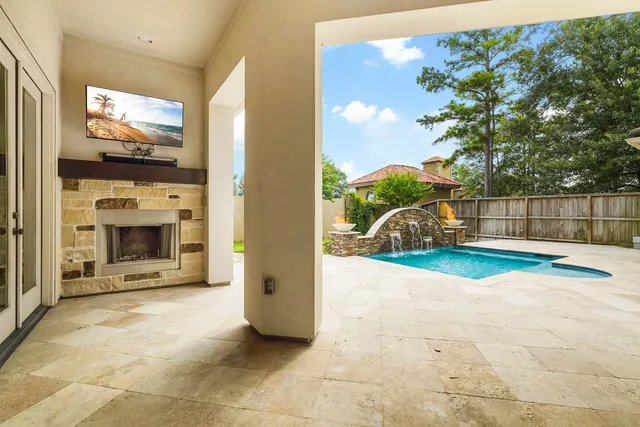 a view of a white house with a large pool and large trees