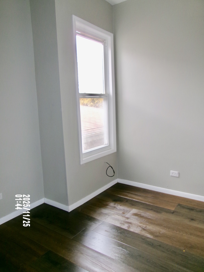 2852 East 91st Street, Unit 2 Chicago, IL 60617 - Photo 15 of 22 a view of an empty room with wooden floor and a window