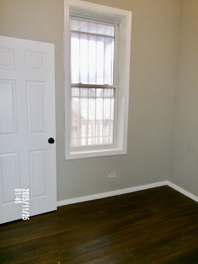 2852 East 91st Street, Unit 2 Chicago, IL 60617 - Photo 18 of 22 a view of an empty room with wooden floor and a window