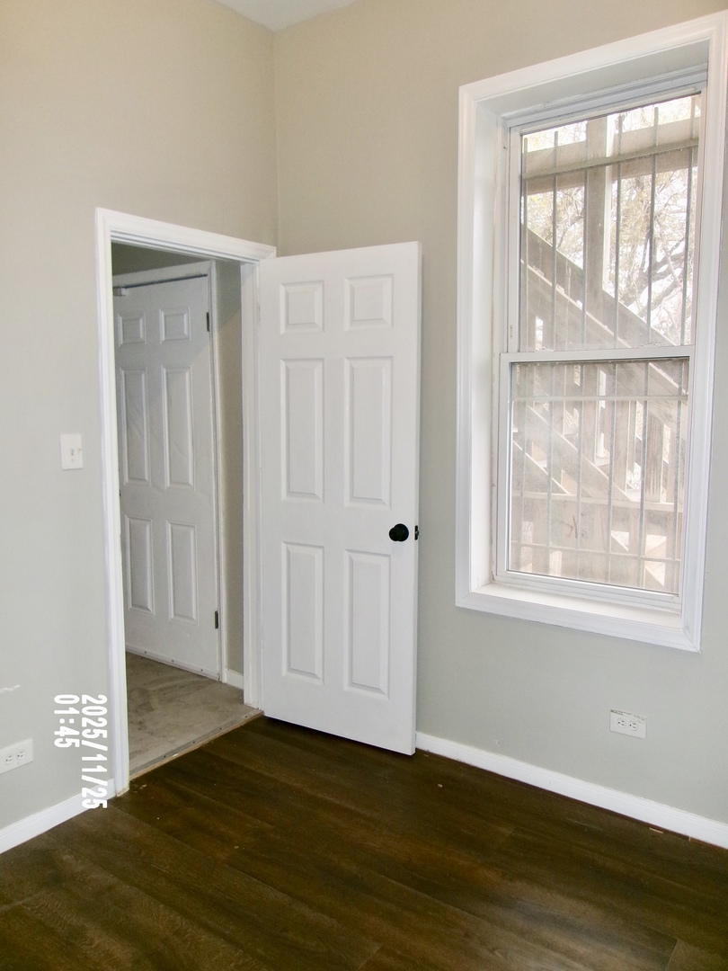 2852 East 91st Street, Unit 2 Chicago, IL 60617 - Photo 19 of 22 a view of an empty room with wooden floor and a window