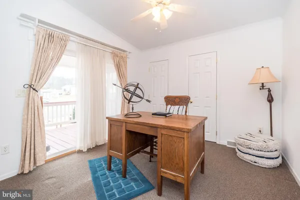 a view of a workspace with furniture and a window