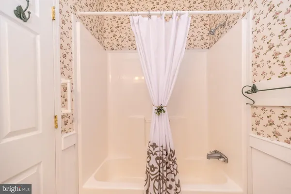 a bathroom with a shower curtain and a window