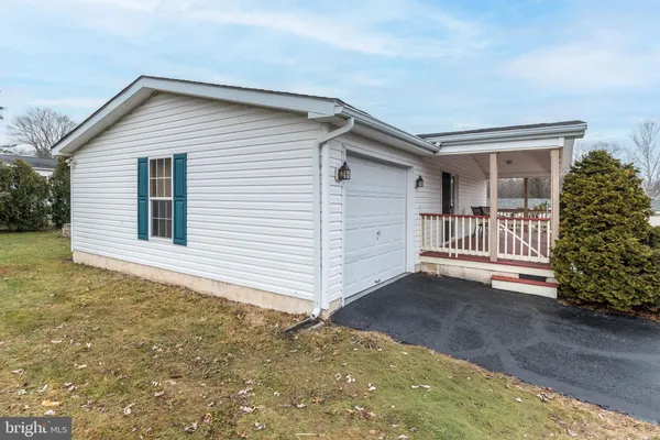 a view of a house with a small yard and garage