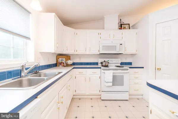 a kitchen with granite countertop white cabinets and white appliances