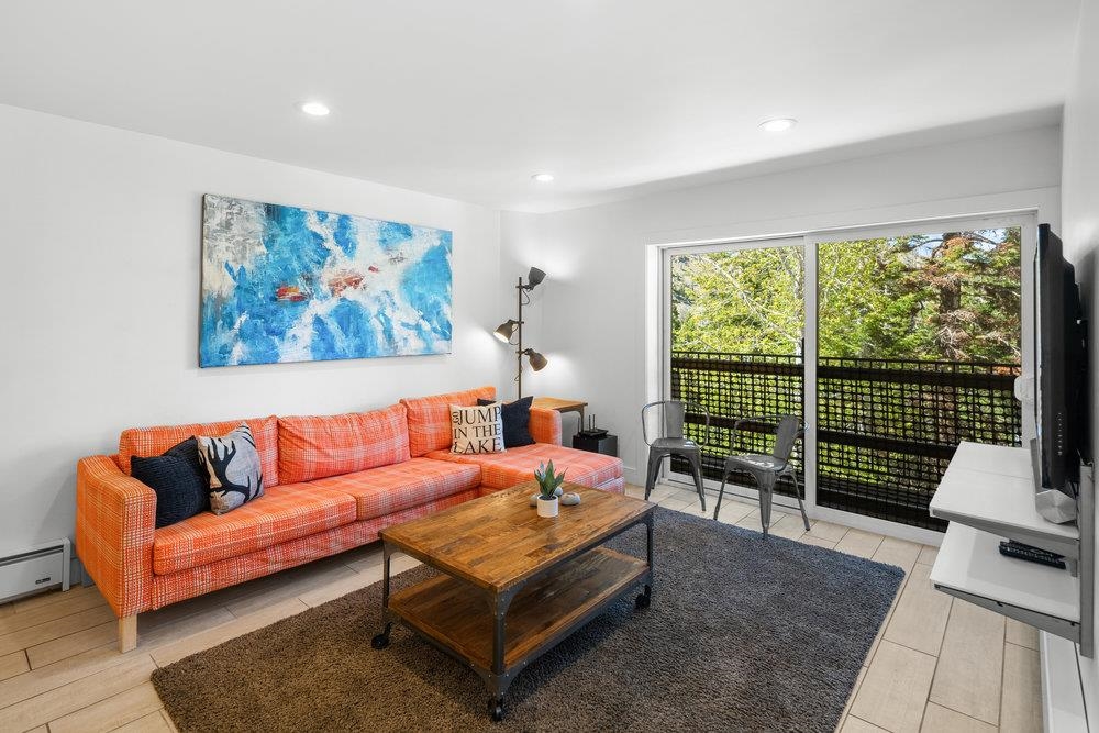 a living room with furniture a rug and a large window