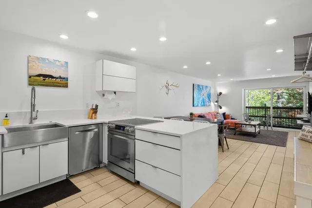 a living room with furniture and a view of kitchen