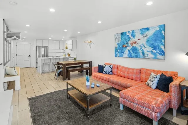 a living room with furniture a rug and a large window