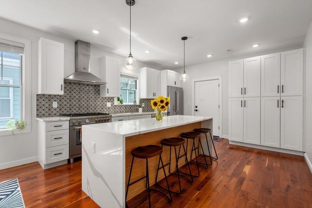 a kitchen with stainless steel appliances granite countertop a table chairs stove a sink and a refrigerator