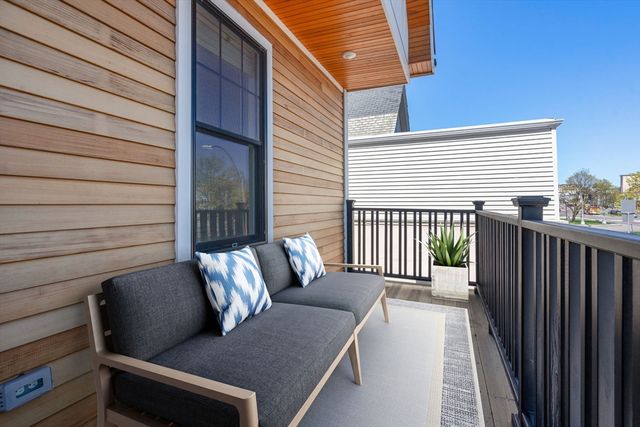 a balcony with wooden floor and outdoor seating