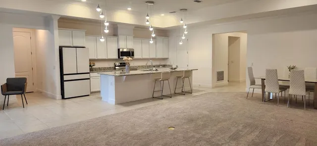 a kitchen with kitchen island a stove a table and chairs in it