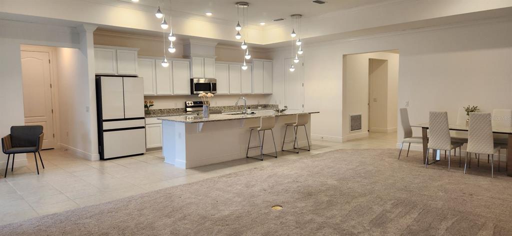 13795 Southwest 137th Way Newberry, FL 32669 - Photo 3 of 26 a kitchen with kitchen island a stove a table and chairs in it