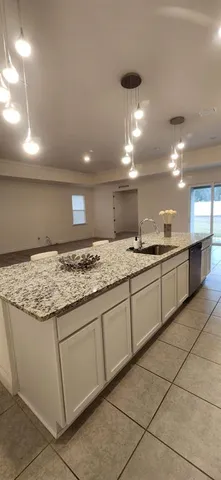 a large kitchen with a sink and cabinets