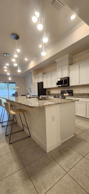 13795 Southwest 137th Way Newberry, FL 32669 - Photo 8 of 26 a kitchen with stainless steel appliances granite countertop a sink a stove a microwave a counter top and cabinets