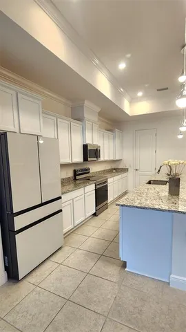 a kitchen with granite countertop cabinets and white stainless steel appliances