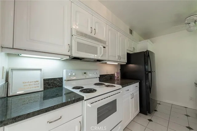 a kitchen with stainless steel appliances granite countertop white cabinets and a stove