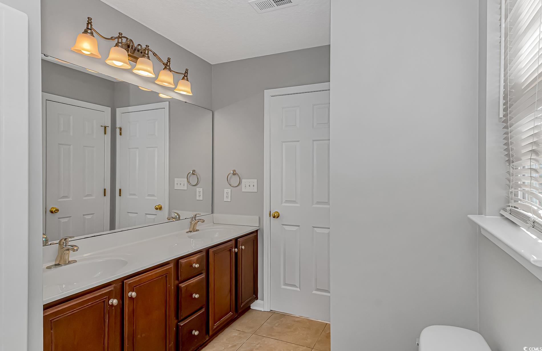 502 Lake Shore Drive Surfside Beach, SC 29575 - Photo 12 of 25 Full bathroom featuring double vanity and light tile patterned flooring