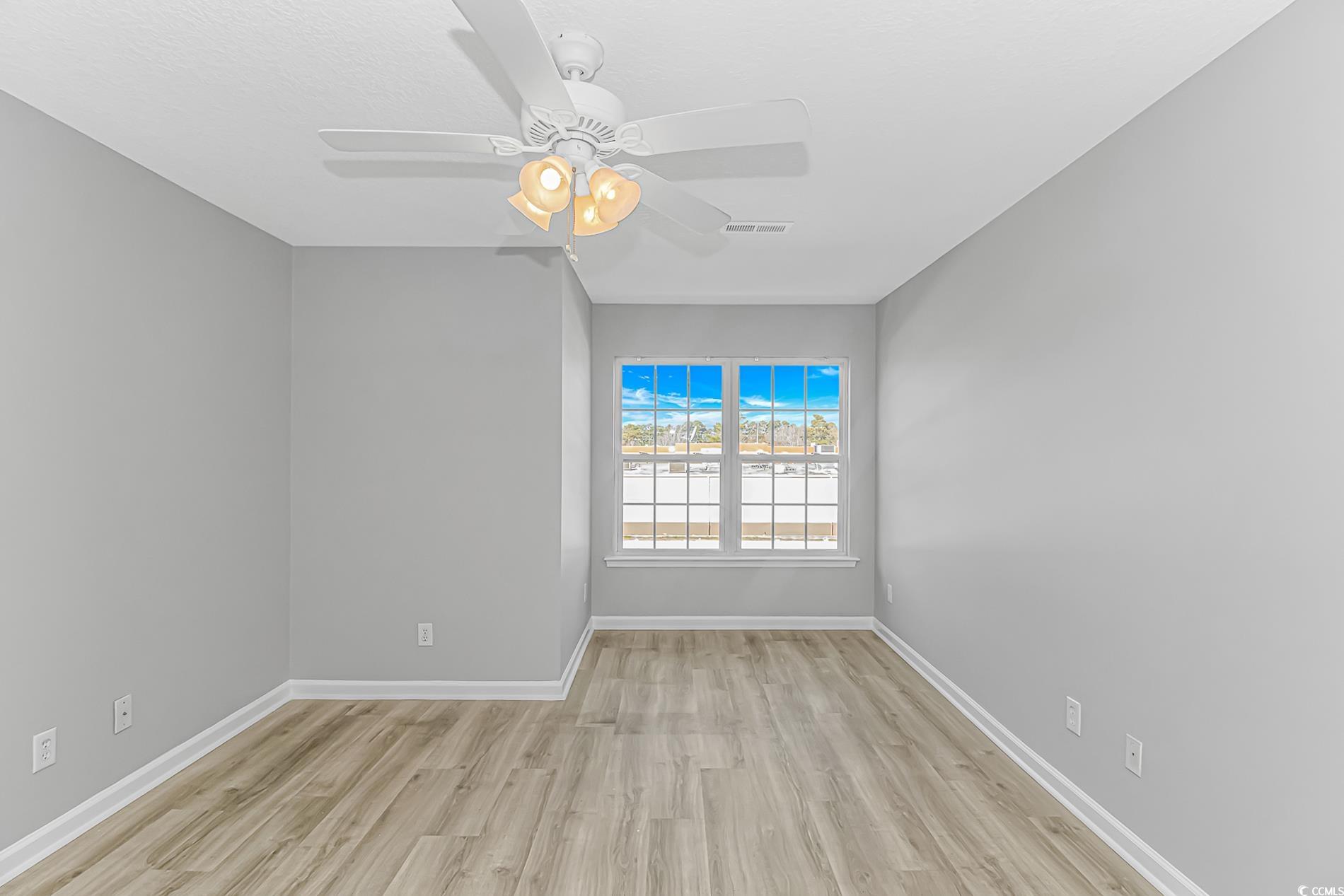 502 Lake Shore Drive Surfside Beach, SC 29575 - Photo 15 of 25 Unfurnished room with light wood-style flooring and a ceiling fan