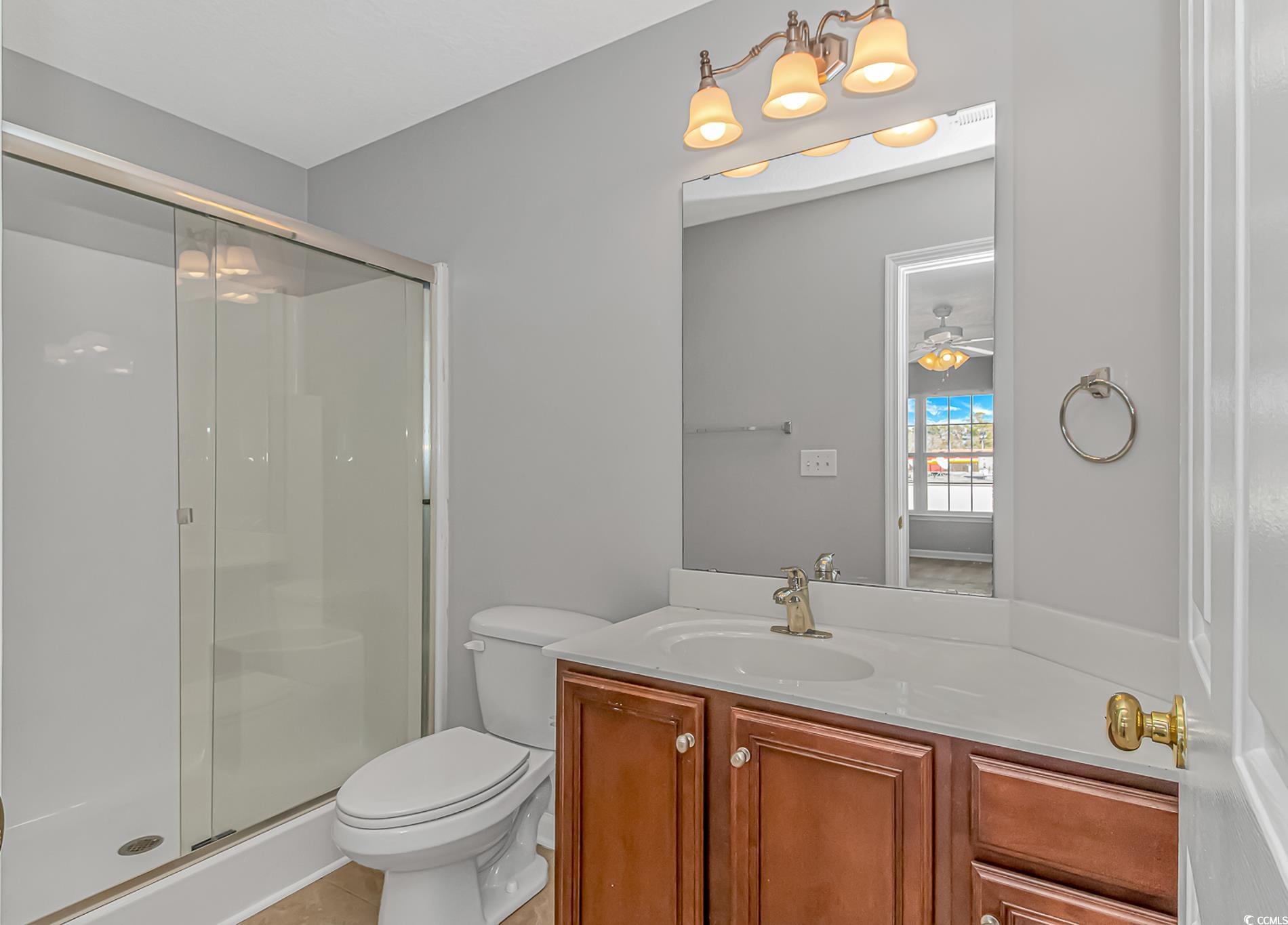 502 Lake Shore Drive Surfside Beach, SC 29575 - Photo 17 of 25 Bathroom with vanity, a shower stall, and a ceiling fan