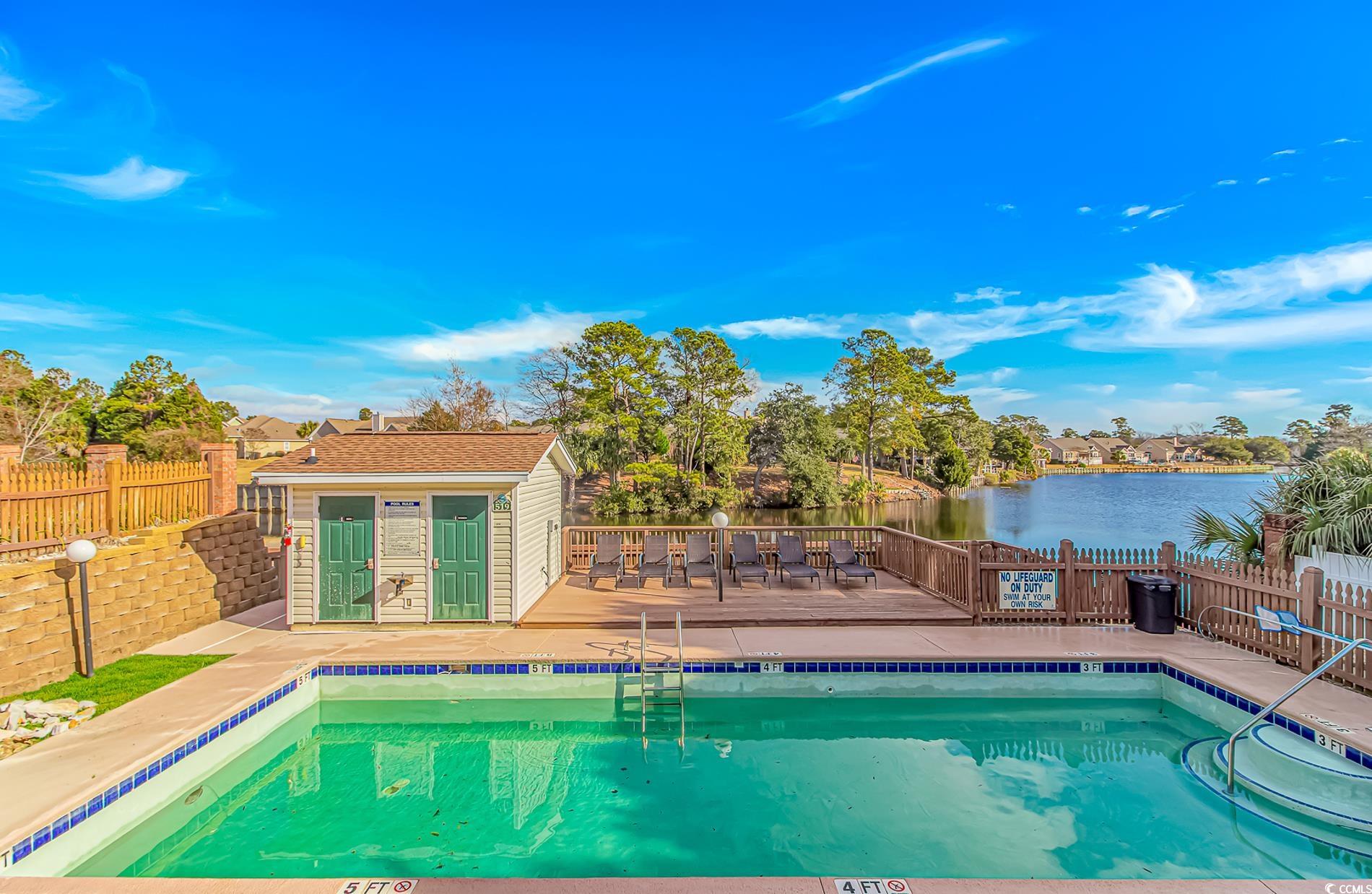 502 Lake Shore Drive Surfside Beach, SC 29575 - Photo 24 of 25 Community pool with an outdoor structure, a fenced backyard, a deck with water view, and a patio