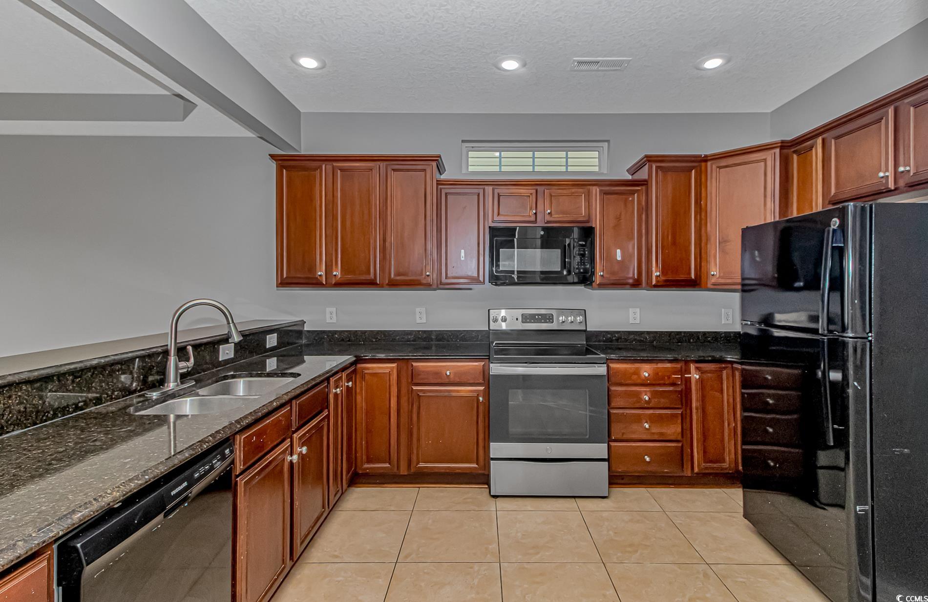 502 Lake Shore Drive Surfside Beach, SC 29575 - Photo 3 of 25 Kitchen featuring black appliances, dark stone countertops, light tile patterned flooring, a textured ceiling, and recessed lighting