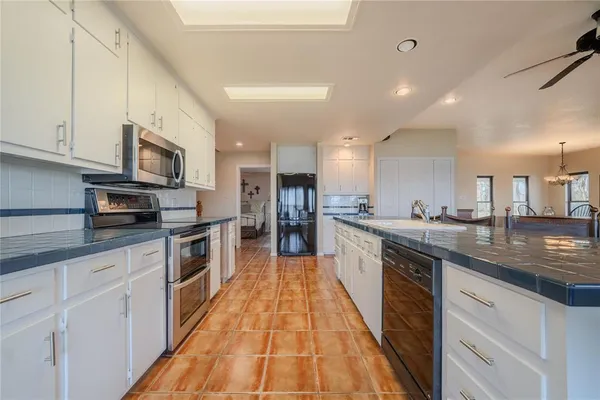 a kitchen with stainless steel appliances granite countertop a refrigerator and a stove top oven