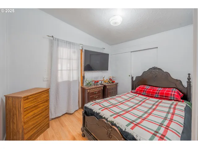 a bedroom with a bed and a flat screen tv