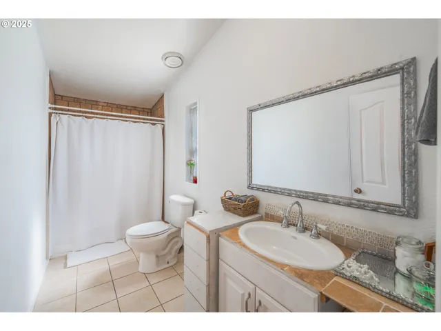 a bathroom with a sink toilet a mirror and shower