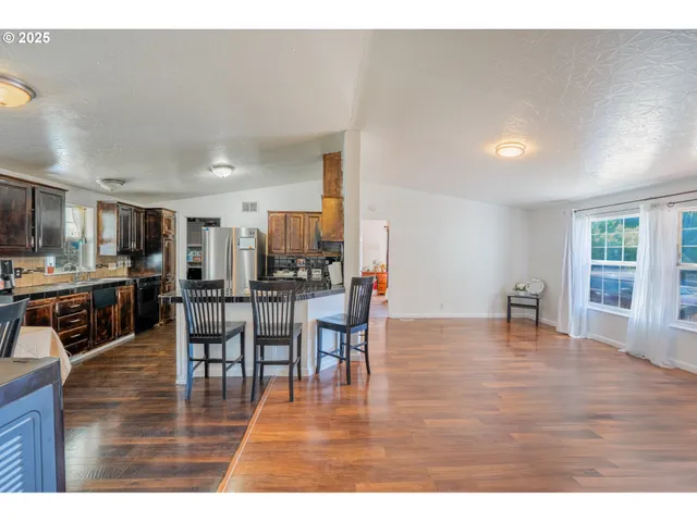 a kitchen with stainless steel appliances wooden cabinets and dining table