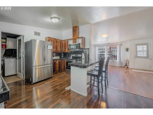 a kitchen with a table chairs refrigerator and microwave