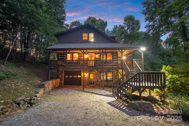 a view of a brick house with a small yard and a deck