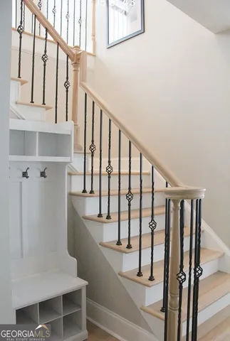 a view of staircase with lots of frames on wall and a window