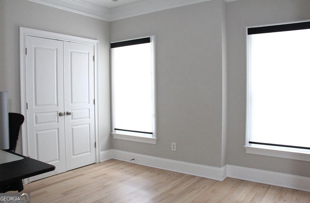 996 Pitts Road, Unit D Sandy Springs, GA 30350 - Photo 26 of 39 an empty room with wooden floor closet and windows