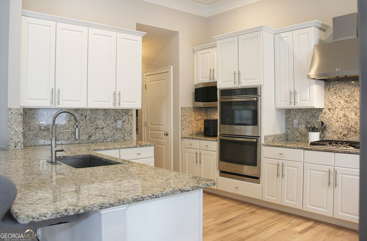 996 Pitts Road, Unit D Sandy Springs, GA 30350 - Photo 5 of 39 a kitchen with stainless steel appliances granite countertop a sink a stove and a refrigerator