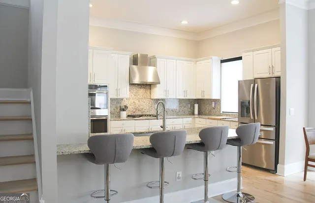 a kitchen with stainless steel appliances granite countertop a sink a stove and a refrigerator
