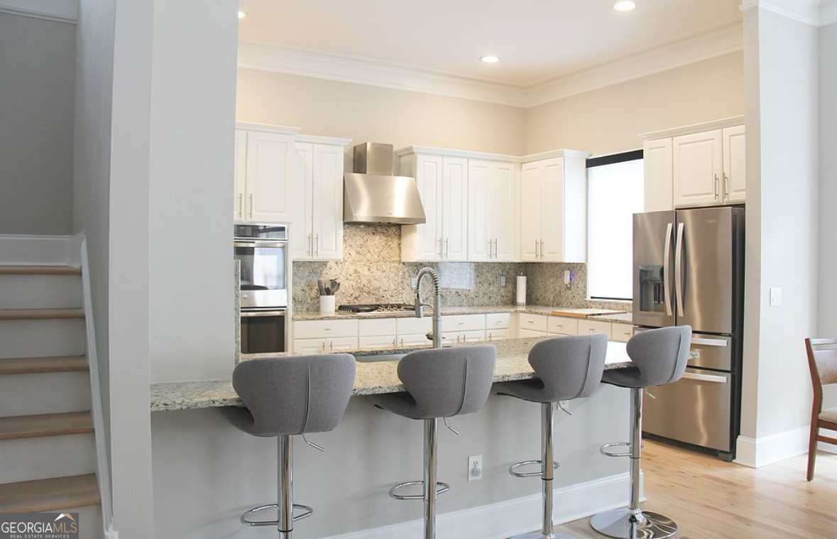996 Pitts Road, Unit D Sandy Springs, GA 30350 - Photo 7 of 39 a kitchen with stainless steel appliances a dining table chairs refrigerator and sink