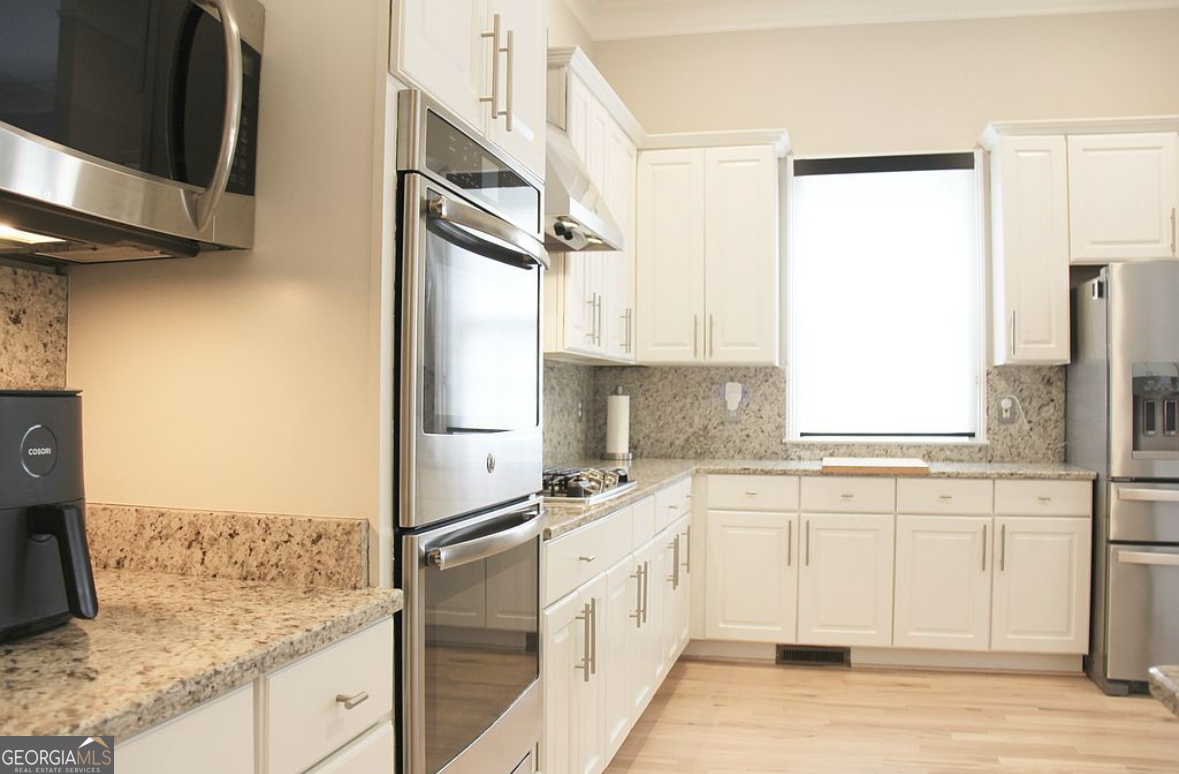 996 Pitts Road, Unit D Sandy Springs, GA 30350 - Photo 8 of 39 a kitchen with stainless steel appliances granite countertop a sink a stove and a refrigerator