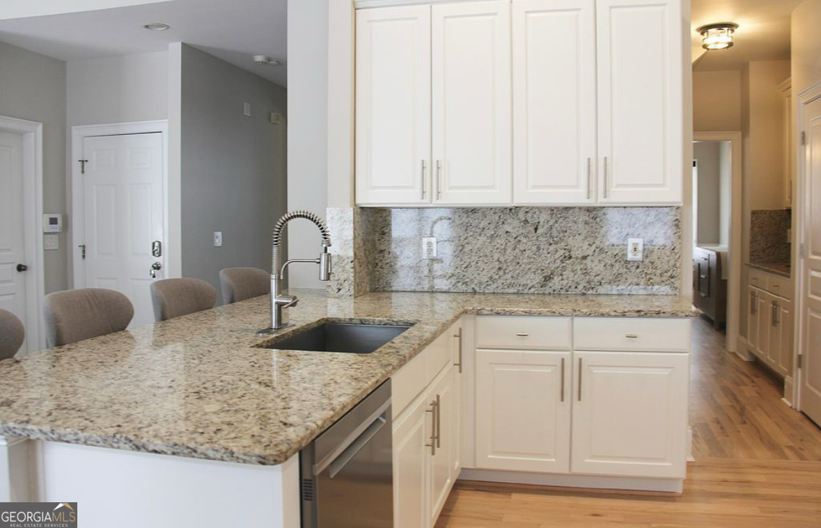 996 Pitts Road, Unit D Sandy Springs, GA 30350 - Photo 9 of 39 a kitchen with granite countertop white cabinets and sink