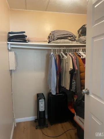 a view of walk in closet with clothes and shoes