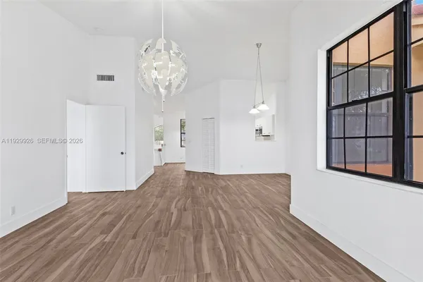 a view of empty room with wooden floor