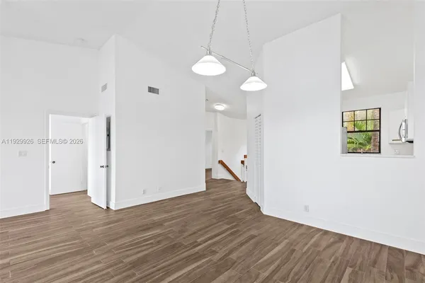 a view of a room with wooden floor and window