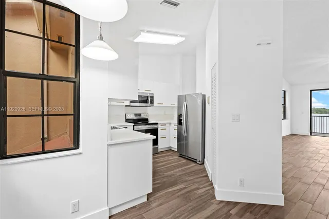 a kitchen with stainless steel appliances a refrigerator and a stove top oven