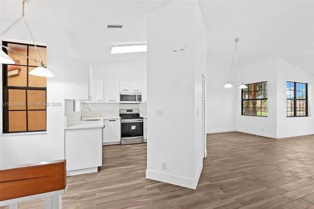 a kitchen with white cabinets and white appliances