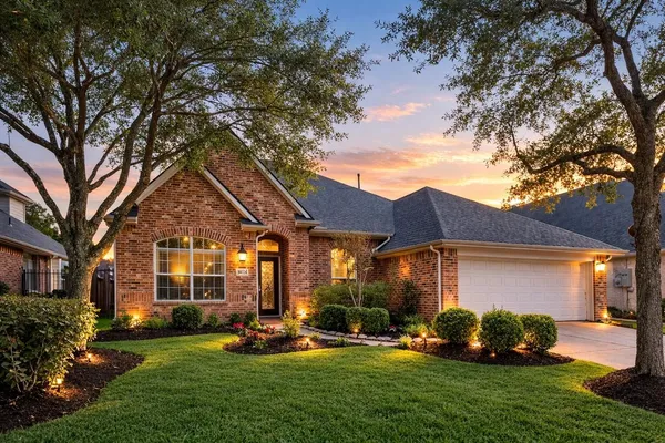 a front view of a house with a yard and green space