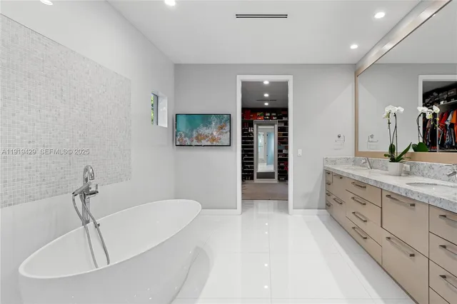 a bathroom with a tub sink and mirror