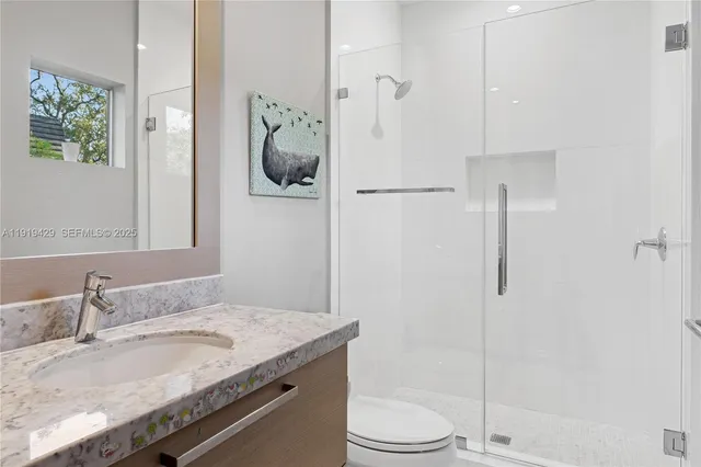 a bathroom with a granite countertop sink a toilet and shower
